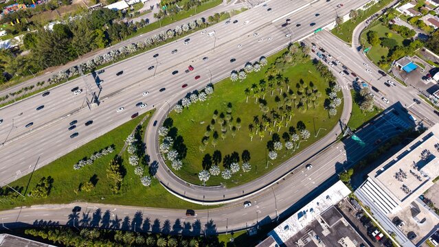 Aerial view of highway cloverleaf interchange with palm trees
