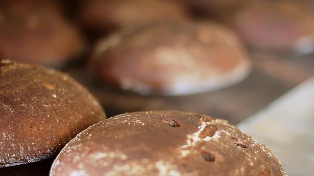 Round brown loaves wooden boards close up. Traditional bakery bread camera pan.
