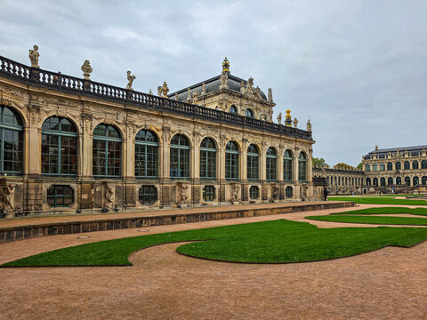 historic baroque palace with ornate sandstone facade, arched windows and formal courtyard gardens in dresden, germany