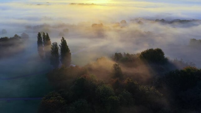 Aerial view of sun rays and long shadows through mist in Heaton Park, Manchester