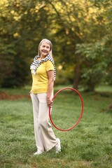 Senior woman with hula hoop in park © New Africa
