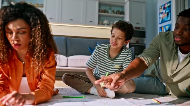Family drawing pencils living room floor. Multiethnic parents son creative play.