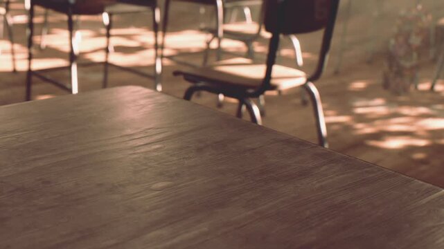 Empty wooden table sits in the foreground of a quiet cafe while chairs are placed around it in the background as soft sunlight streams across the floor during the warm afternoon time of day