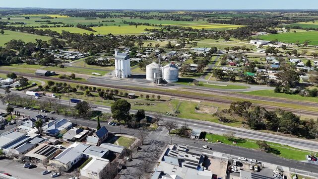 Aerial drone view of town centre of Keith, South Australia, with the Dukes Highway carrying heavy freight trucks, grain silos and bulk storage facilities along the railway line, commercial buildings