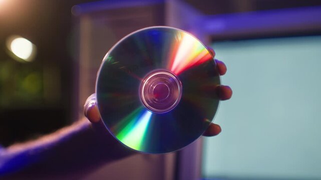 CD disc in hand, compact disc and CD ROM drive of retro desktop computer, inserting disk into old 90s PC tray, vintage data storage technology