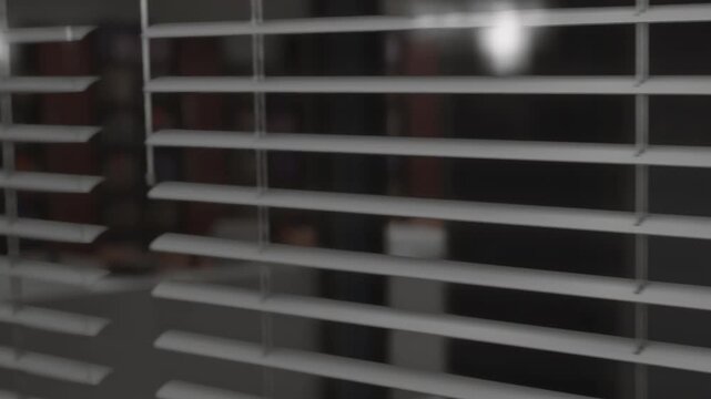 White window blinds hang over a window covering the view of an interior room during the daytime