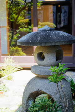 Weathered Stone Lantern Among Green Garden Plants