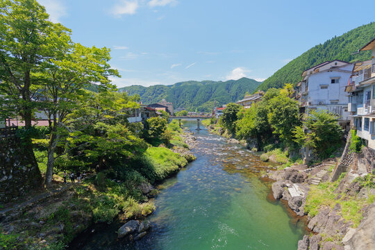 Clear River Through a Town Beneath Green Mountains