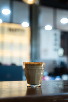 Hot coffee latte with latte art milk foam in cup mug on wood desk on top view. As breakfast In a coffee shop at the cafe,during business work concept,vintage style