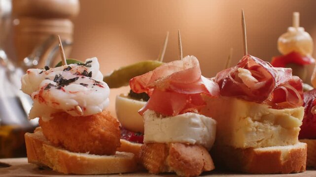 Tapas Spanish pinchos assortment, Basque pintxos with jamon iberico, tortilla, shrimp, stuffed piquillo pepper and egg on bread, traditional bar food close up