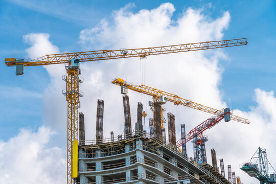 Concrete construction and steel rebar reinforcement at high-rise building site with tower cranes, structural engineering framework for modern architecture and urban development