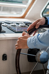 Two hands grip a polished wooden steering wheel © Кристина Пахомова