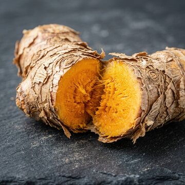 Fresh Turmeric Root Healthy Spice Culinary Ingredient Vibrant Orange Interior on Dark Slate Background
