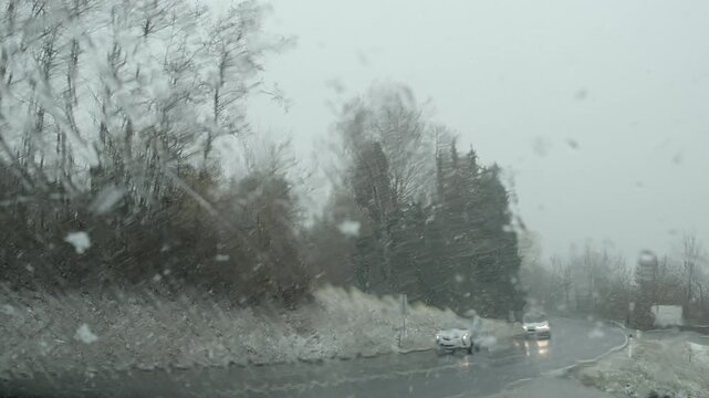Bad weather, road traffic through a windscreen in heavy snowfall, Austria