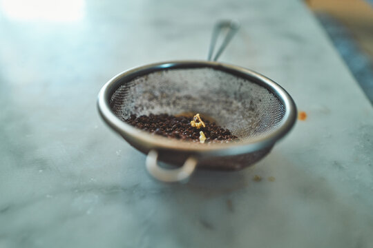 Fine Mesh Tea Strainer with Used Tea Leaves on a Marble Counter