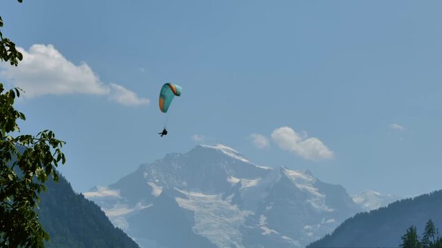 Paragliding and Snowcapped Mountain Peak Jungfraujoch in a Sunny Summer Day in Interlaken, Bernese Oberland, Bern Canton, Switzerland