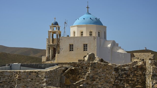 Church with blue dome next to stone ruins, in a mountainous landscape under a blue sky, Church of the Virgin Mary Evangelistria, Chora, Astypalea, Dodecanese, Greek Islands, Greece