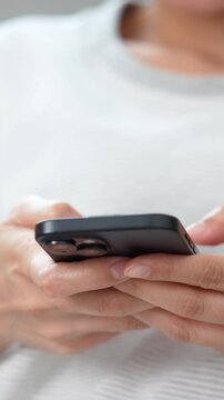 woman holds smart phone in her hands and scrolls through the news feed. Close up of hand uses mobile. point finger on screen, texting text message.