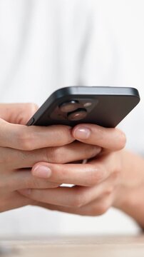 woman holds smart phone in her hands and scrolls through the news feed. Close up of hand uses mobile. point finger on screen, texting text message.