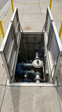 Open hatch reveals an underground valve assembly