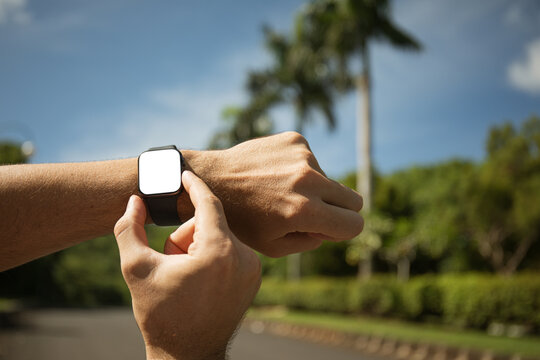 Person interacts with smartwatch while enjoying outdoor weather