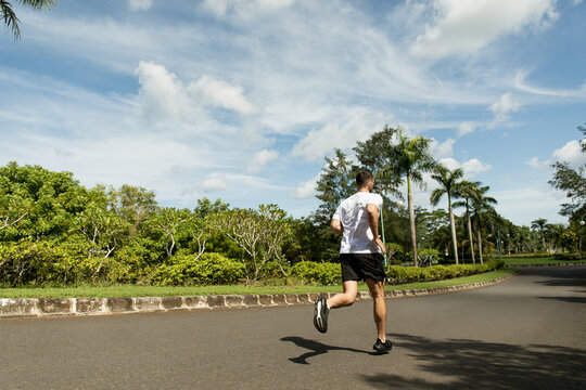 Jogger enjoying a sunny day in a lush park environment