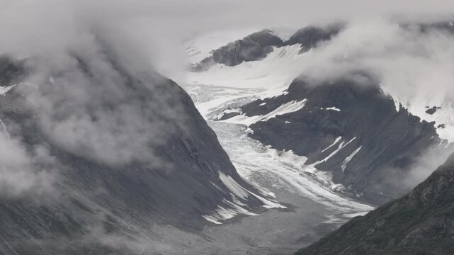 a long zoom in clip of grand pacific glacier on a cloudy day at glacier bay, alaska of the usa