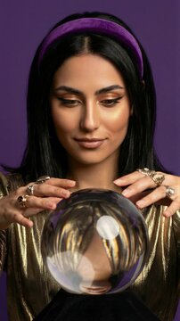 Fortune teller woman with crystal ball and rings on purple background