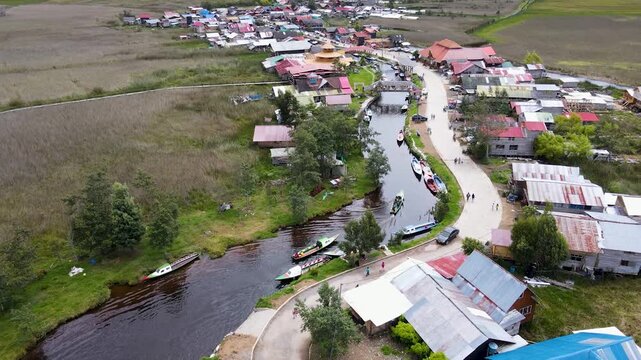 Vuelo bajo sobre el pueblo, r&iacute;o y gente paseando, vista panor&aacute;mica.