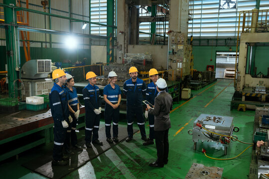 The foreman is checking on operations and holding meetings with his diverse team members in the steel factory.