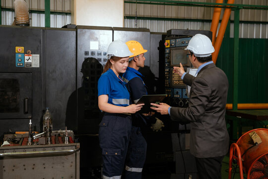 The foreman is checking on operations and holding meetings with his diverse team members in the steel factory.