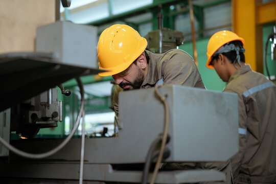 Professional technician engineer with safety helmet hard hat working in industrial manufacturing factory.