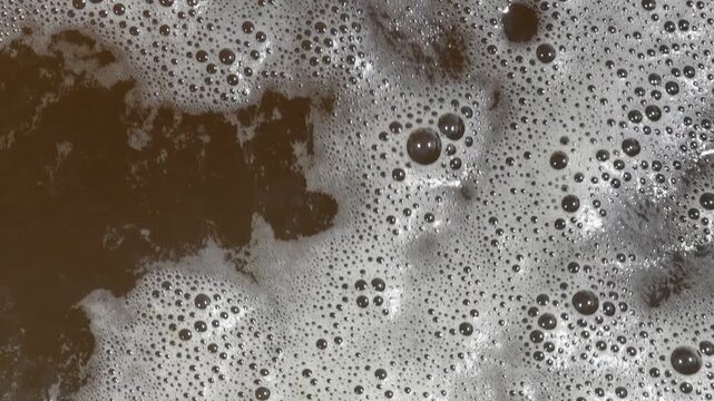 Brown Wastewater Foam Bubble Texture, White Foam and Bubbles Covering Murky Brown Liquid Surface, Abstract Organic Circular Pattern Representing Water Pollution Contamination Imagery