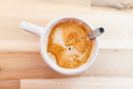 latte with milk froth in pink mug shot from top down perspective