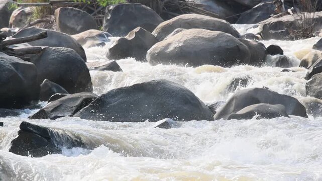 Rushing River Water Flowing Around Smooth Granite Boulder, Creating Energetic Whitewater Rapids, Textured Stream Current Movement, Natural Mountain Landscape and Refreshing Outdoor Scenery