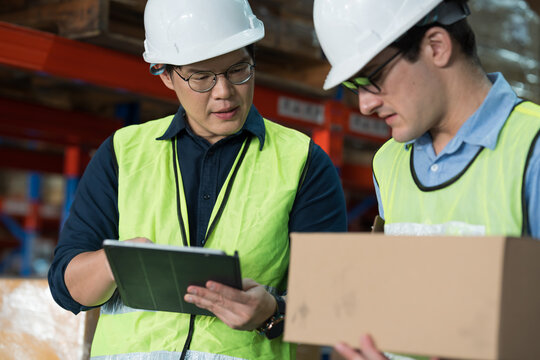 Close up of warehouse worker discussing, collaborating on logistics management and inventory operations in distribution center