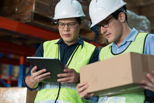 Close up of warehouse worker discussing, collaborating on logistics management and inventory operations in distribution center