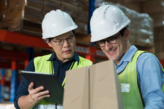 Close up of warehouse worker discussing, collaborating on logistics management and inventory operations in distribution center