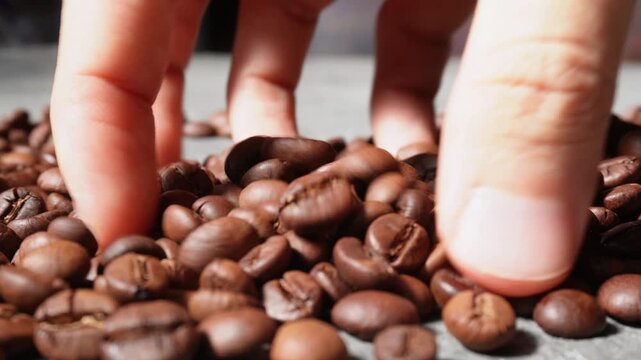 Hand playing with coffe beans
