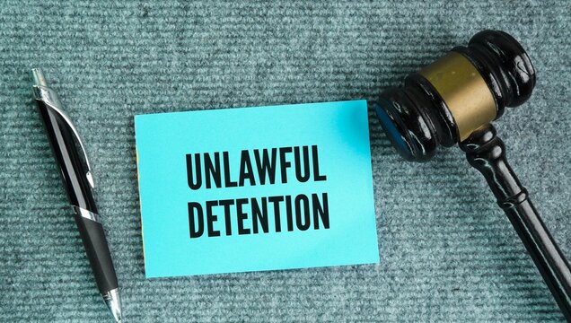 Judge's gavel and paper with the words unlawful detention or false imprisonment happens when someone restricts another person's freedom of movement without legal authority or valid justification