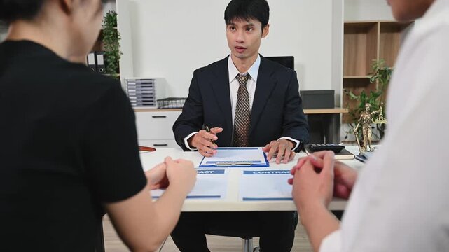 Unidentifiable couple having a serious discussion with a lawyer over a divorce contract.