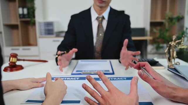 Unidentifiable couple having a serious discussion with a lawyer over a divorce contract.