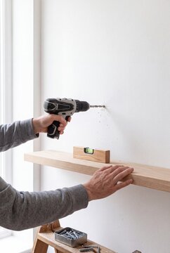 Installing a wooden shelf with a drill