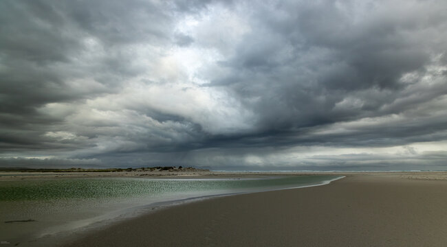 moody late afternoon light falling upon Grotto Lagoon and rocky coastline, Hermanus, South Africa