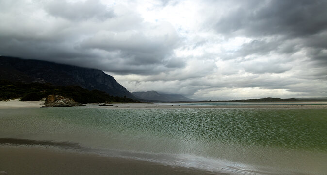 moody late afternoon light falling upon Grotto Lagoon and rocky coastline, Hermanus, South Africa