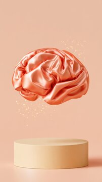 Satin cloth shaped into human brain floating over round beige podium on peach background, creative thinking concept