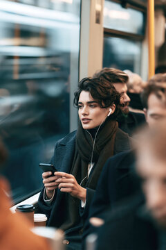 Young Woman Using Smartphone on Busy City Commute