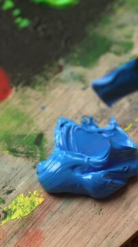 Close up of blue textured oil paint applied to a palette using a painting palette knife. Creative hobby, artistic tools and painting materials concept.