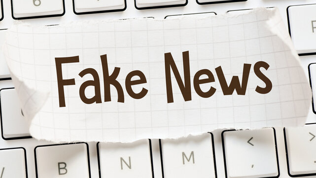 Fake News Concept with Paper Headline on Computer Keyboard