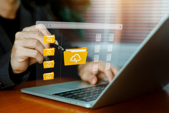 Businessman managing cloud storage and digital files on a laptop, with virtual folders and connected documents illustrating online data management, file sharing, and cloud computing technology.